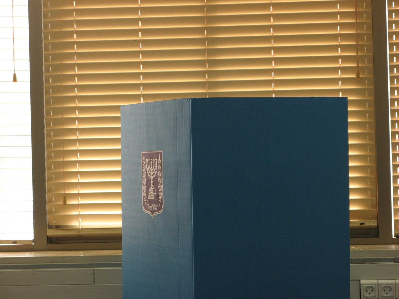 Cabine de votação com o emblema do Estado de Israel.