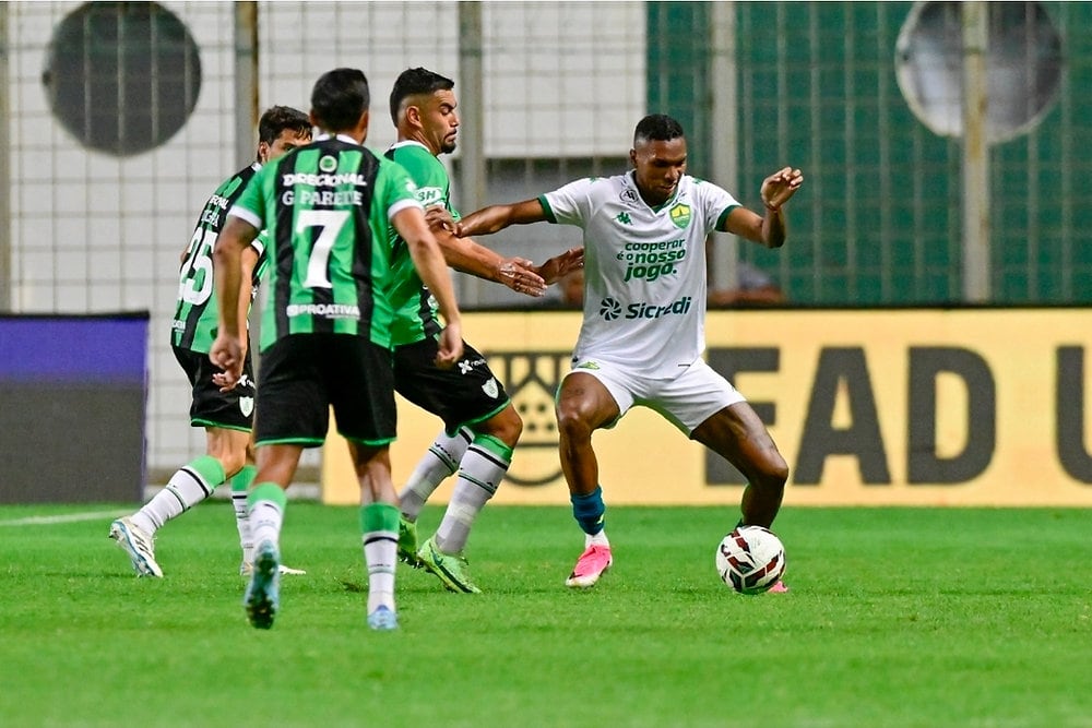 Jogador do Cuiabá disputa a bola com jogadores do América-MG em partida da Série B.