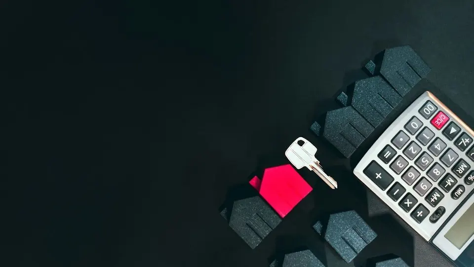 Ilustração com casas, chave e calculadora, símbolos do financiamento imobiliário.