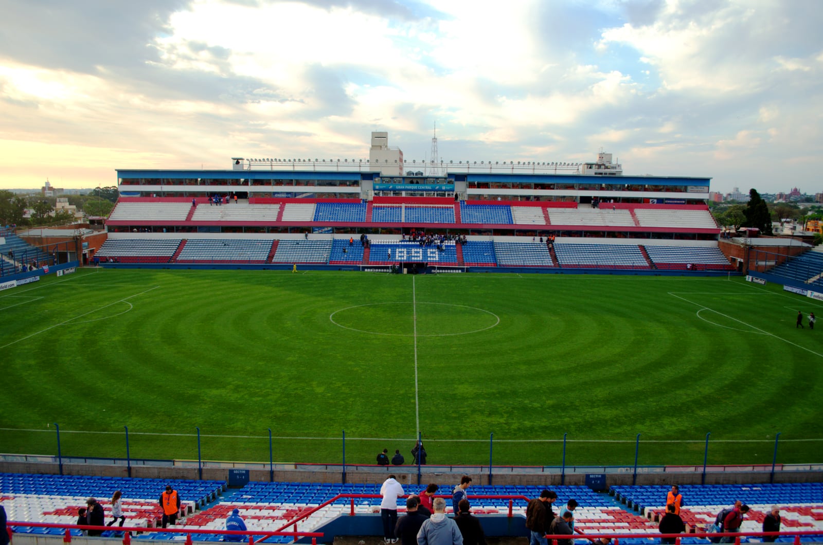 Vista do Estadio Gran Parque Central, em Montevidéu, com o gramado e as arquibancadas azuis e vermelhas.