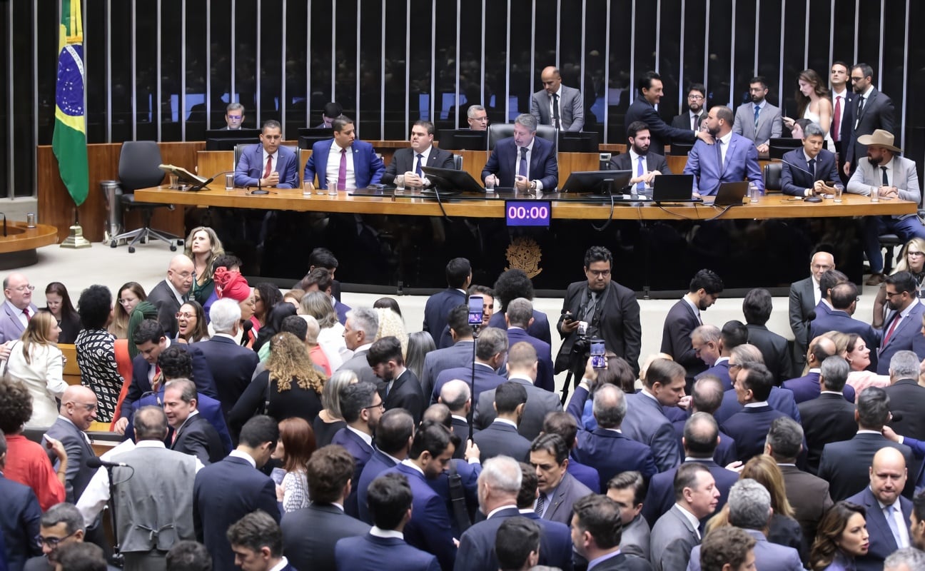 Sessão no plenário da Câmara dos Deputados, com integrantes da Mesa Diretora à frente e deputados reunidos ao redor.