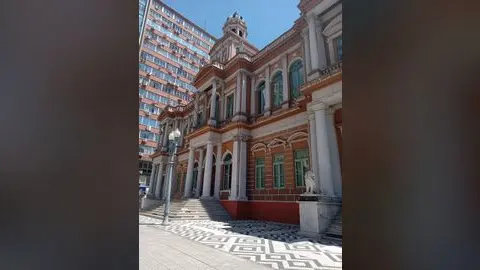 Fachada lateral do Paço dos Açorianos, sede da Prefeitura de Porto Alegre, com estátua de leão e calçada em mosaico.