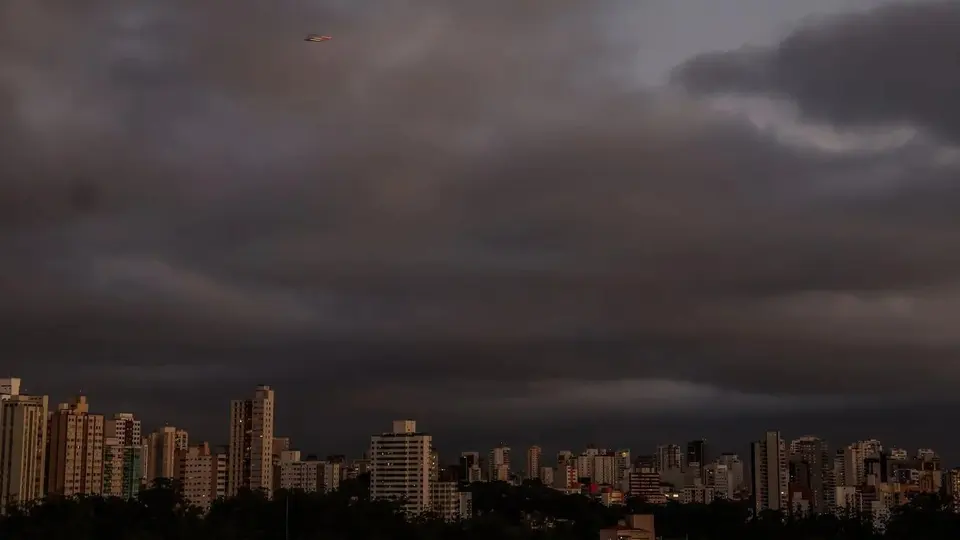 Raios iluminam o céu durante temporal sobre área urbana.