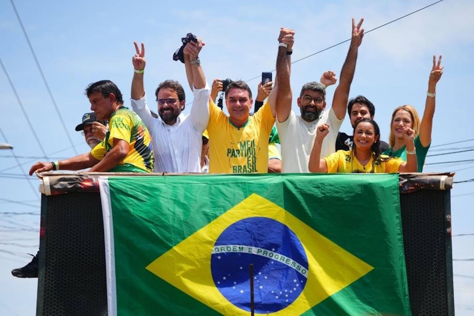 Flávio Bolsonaro discursa em ato de campanha no Pará, com a bandeira do Brasil em primeiro plano.