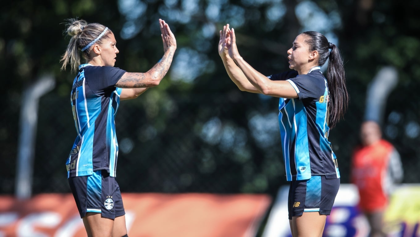 Jogadoras do Grêmio comemoram durante partida do futebol feminino gaúcho.