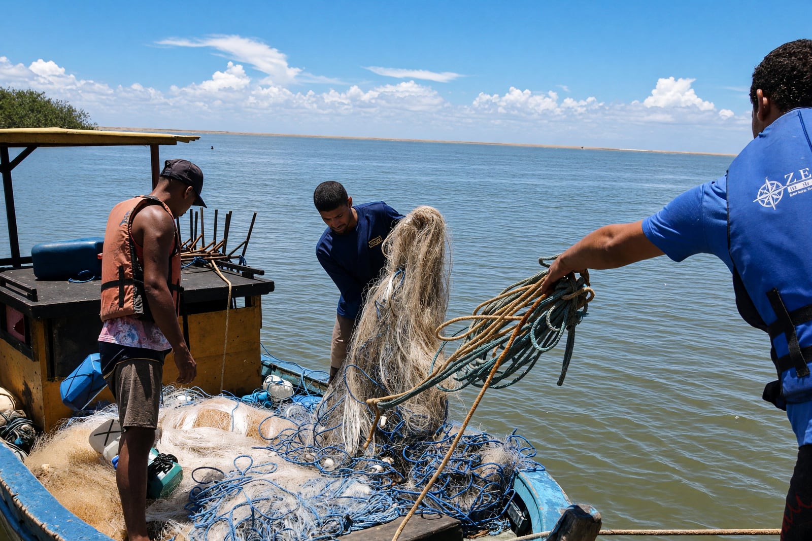 Pescadores recolhem redes em barco na região do Espírito Santo onde a pesca volta a ser permitida.