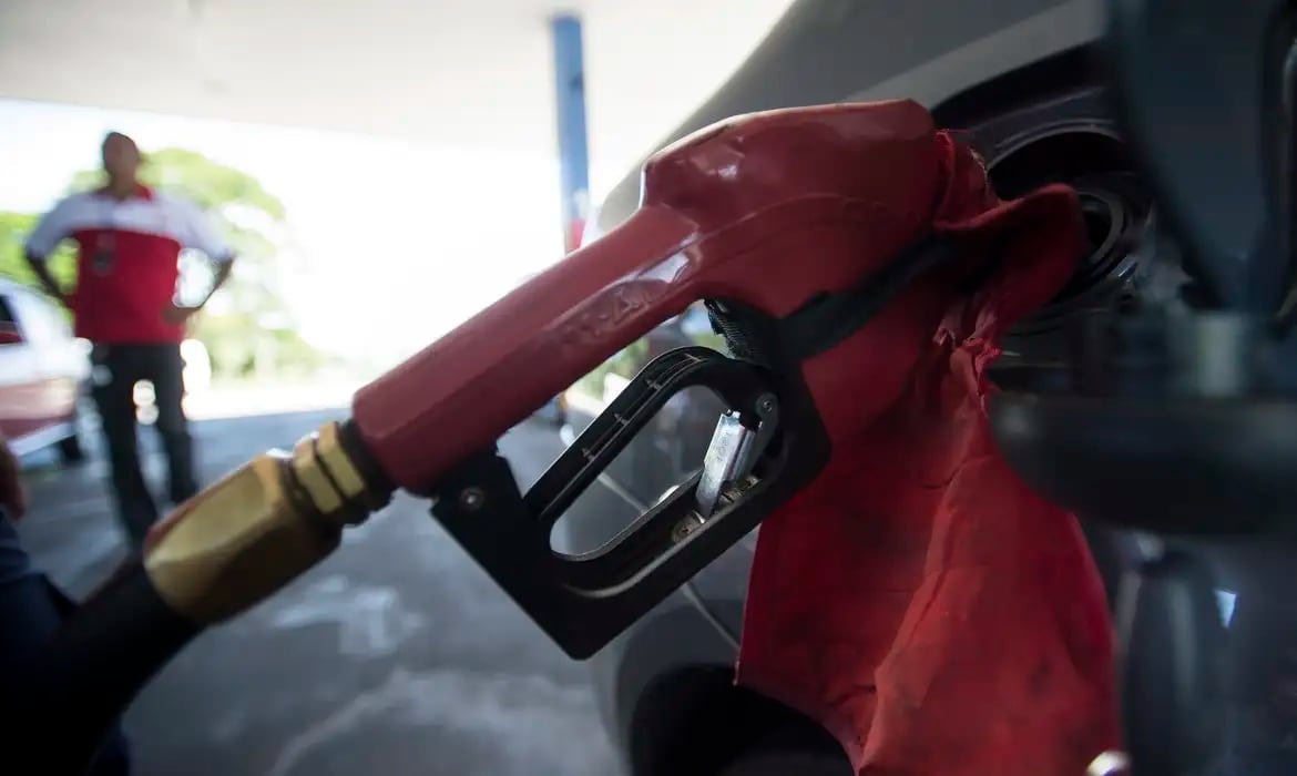Bomba de combustível em posto de abastecimento, com display de preço e mangueira de gasolina