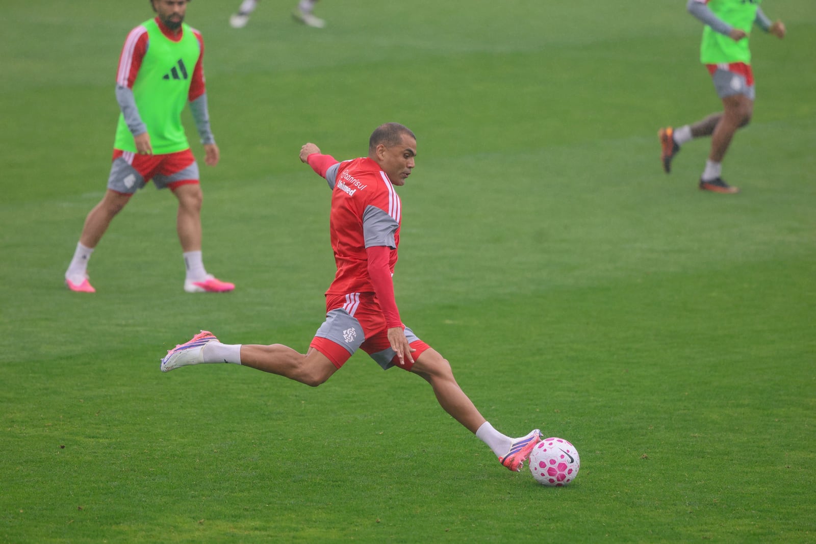 Jogador do Sport Club Internacional chuta a bola durante treino no gramado.