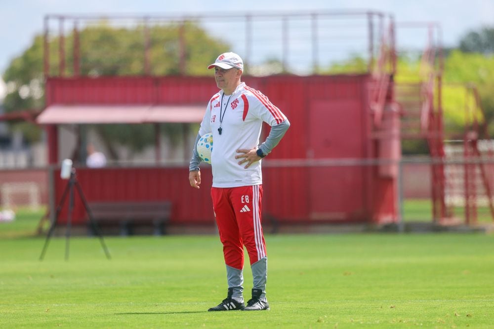 O técnico Eduardo Baptista acompanha um treino do Internacional em campo, com bola na mão.