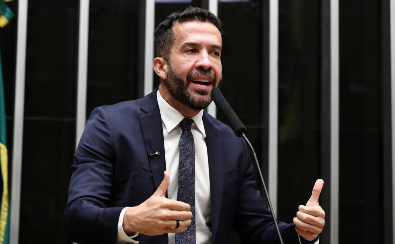 Deputado discursa ao microfone no Plenário da Câmara dos Deputados, de terno e gravata, gesticulando com as duas mãos.