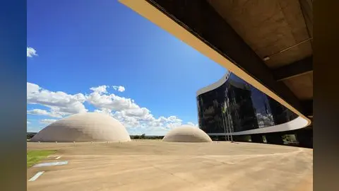 Vista da sede do Tribunal Superior Eleitoral, em Brasília, com as cúpulas sob céu azul e nuvens.