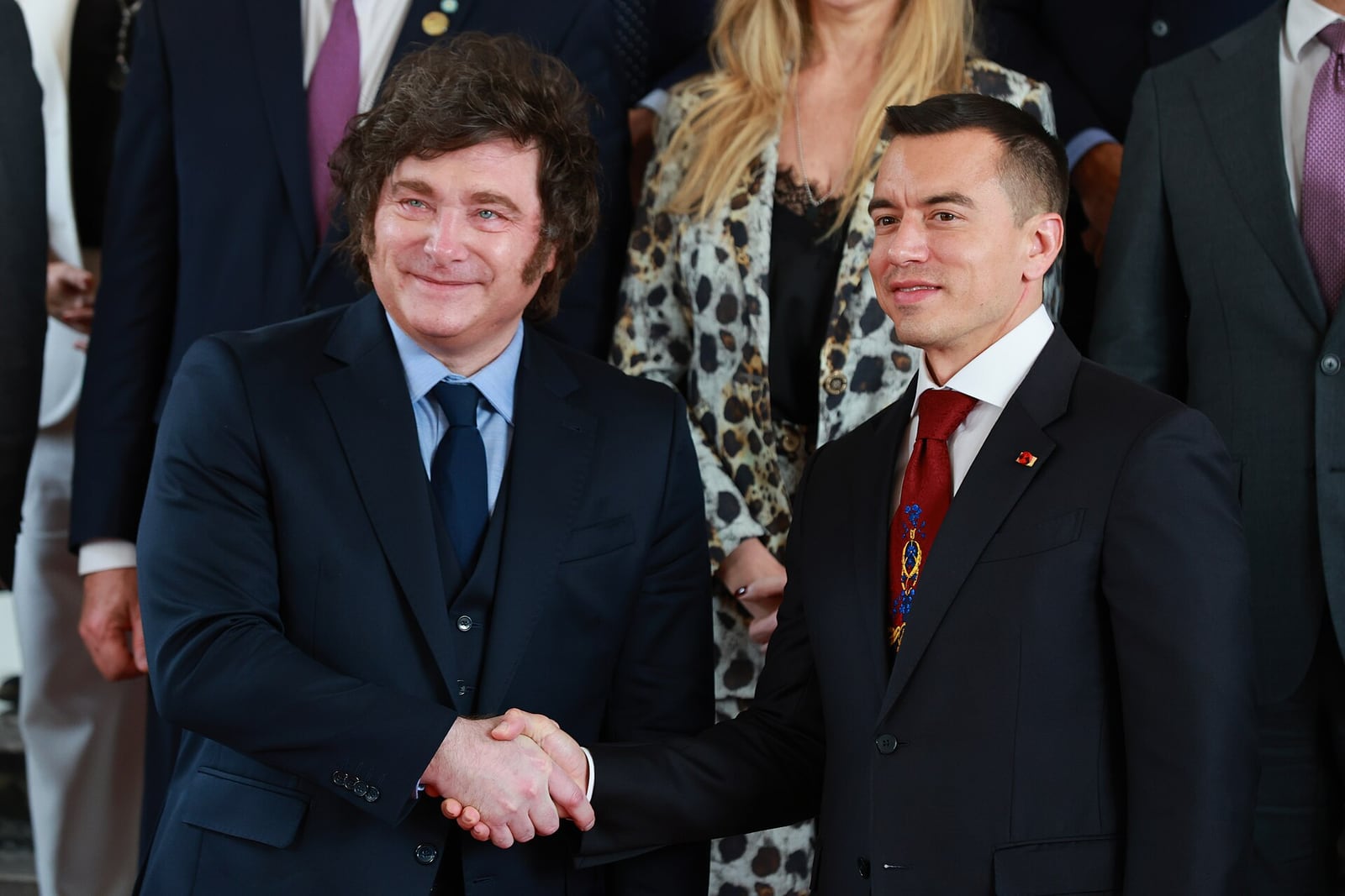 Javier Milei cumpre autoridade equatoriana em encontro de gabinetes em Quito, com bandeiras ao fundo