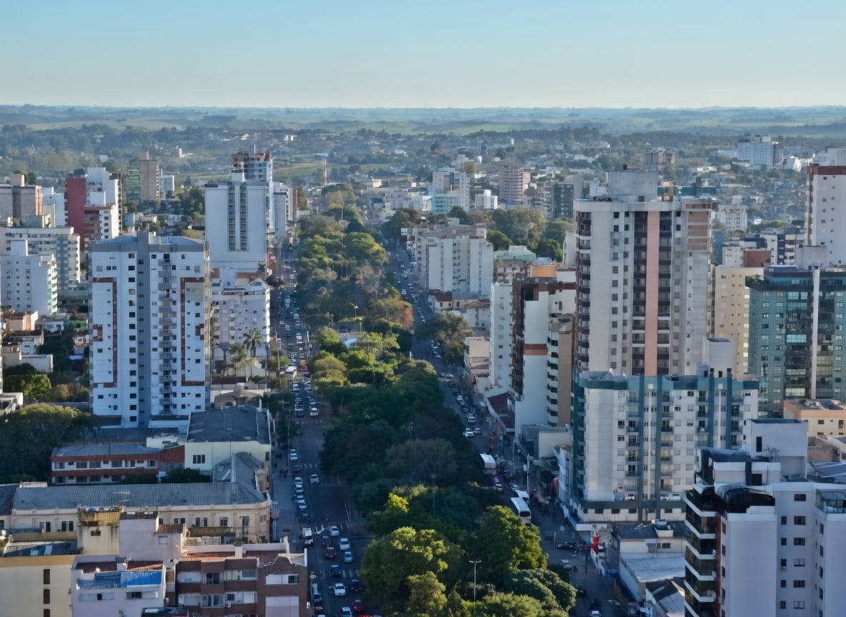 Vista aérea de Passo Fundo, com prédios residenciais e comerciais e uma avenida arborizada.
