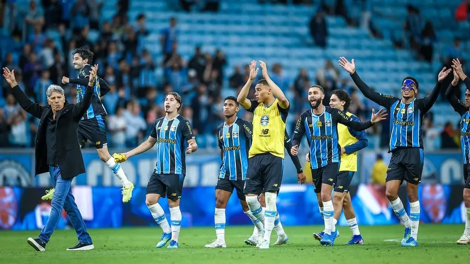 Jogadores do Grêmio comemoram junto à torcida nas arquibancadas da Arena, com o técnico Renato Gaúcho entre eles