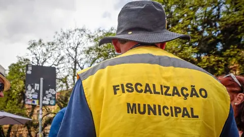 Agente de fiscalização municipal em área pública de Porto Alegre, durante a operação de limpeza do segundo turno.