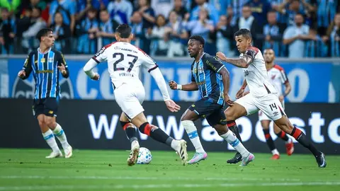 Grêmio e Athletico-PR disputam a bola em partida do Campeonato Brasileiro, na Arena do Grêmio.
