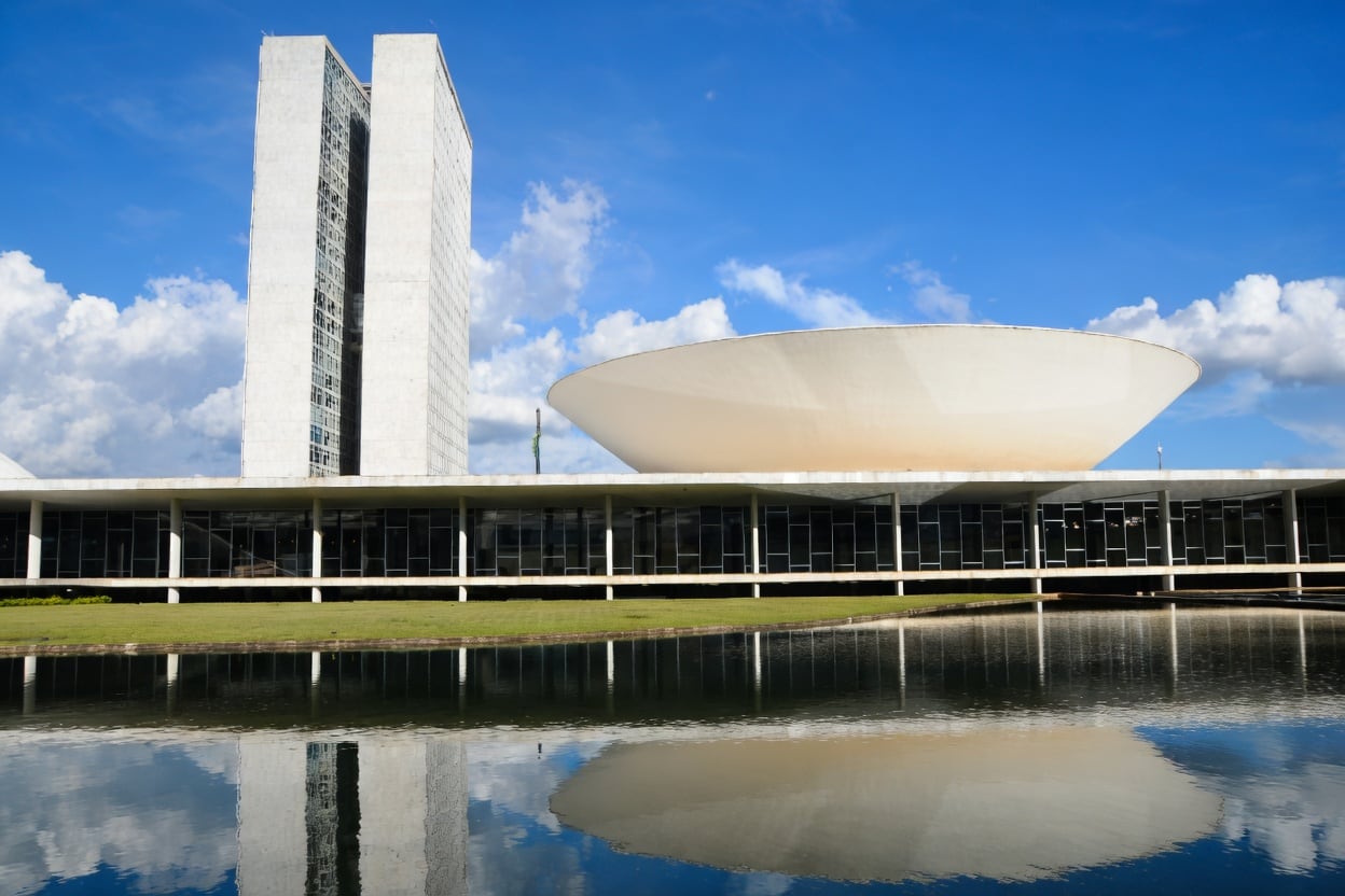 Edifício do Congresso Nacional, em Brasília, com as torres e a cúpula do Legislativo federal refletidas no espelho d'água.