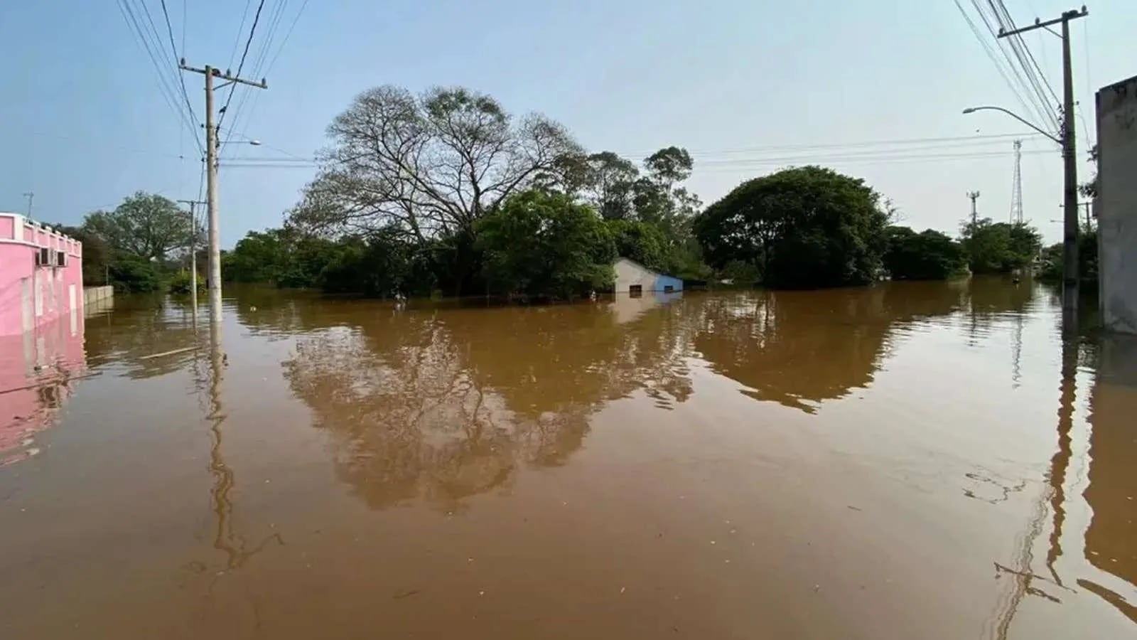 Área atingida pela enchente no Oeste gaúcho, com água cobrindo ruas e residências.