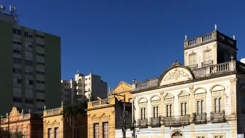 Casarões no entorno da Praça Coronel Pedro Osório, em Pelotas, com fachadas antigas ao redor de uma área arborizada