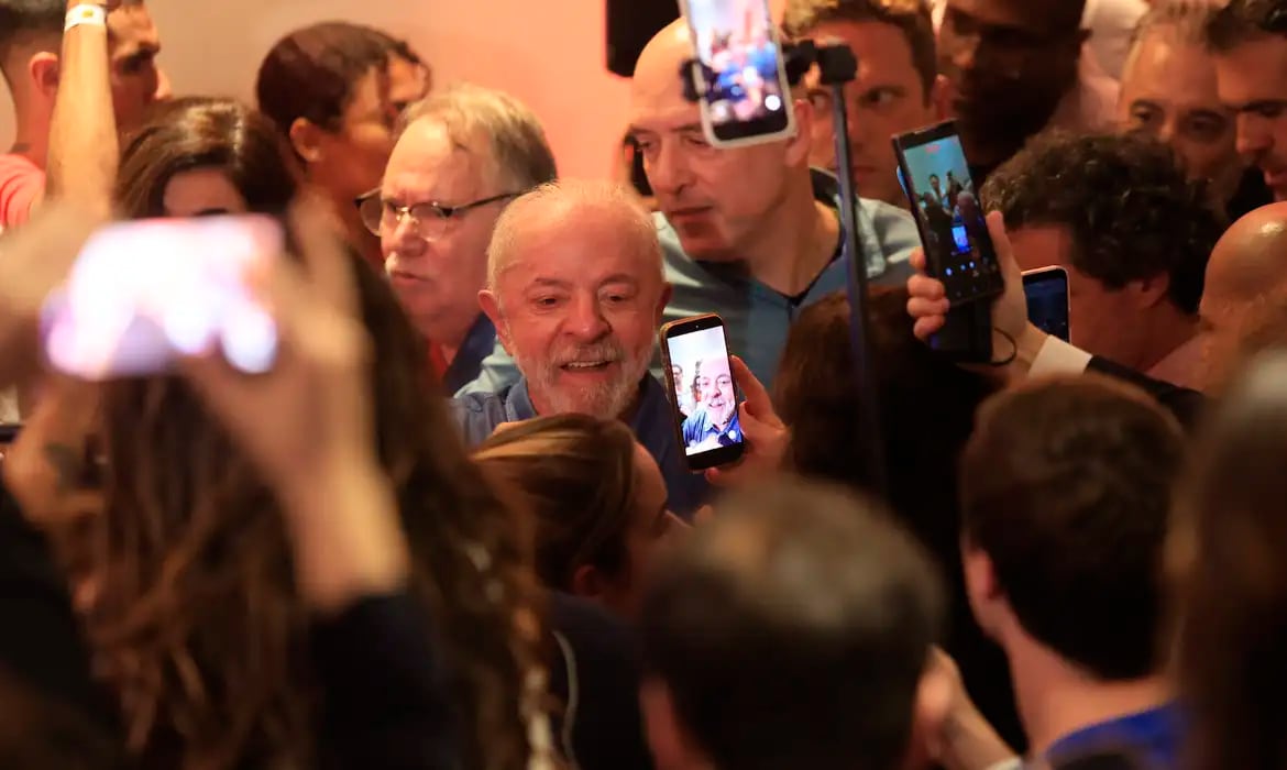 Lula cercado por apoiadores em evento público, após a divulgação dos cumprimentos de líderes estrangeiros pela reeleição.